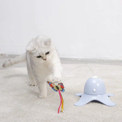 White cat playing with a colorful toy on a light gray background